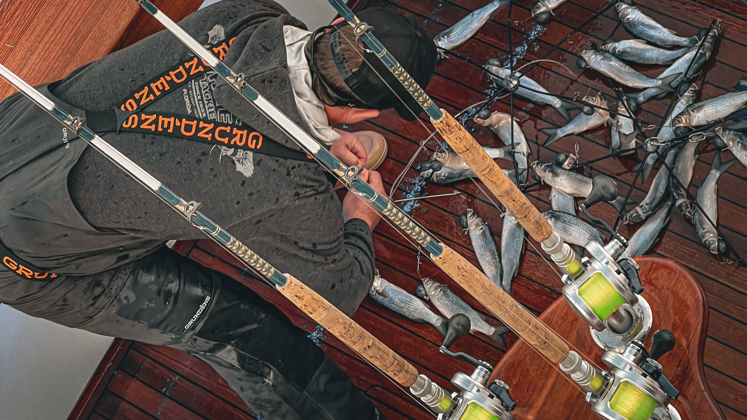 Person rigging dredges with mullet in a teak cockpit of a sportfish boat 