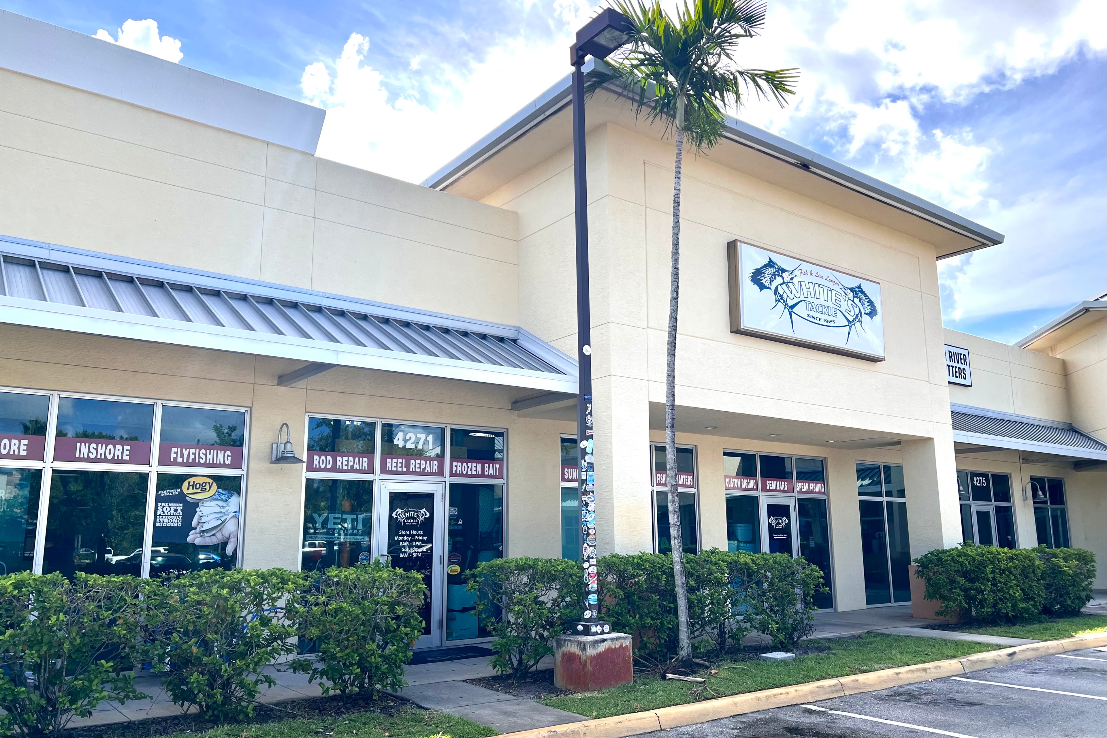 White's Tackle store front building with a palm tree and clear sky